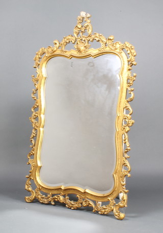 A shaped bevelled plate wall mirror contained in a decorative gilt frame 107cm x 74cm 
