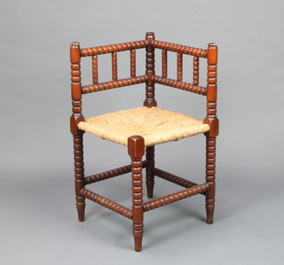 A mahogany bobbin turned corner chair with woven rush seat