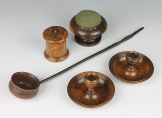 A 19th Century turned lignum pedestal pin cushion 7cm x 9cm, a pair of olive wood campaign style stub candlesticks 5cm x 10cm (1 with damage to sconce), a cylindrical treen string box 7cm x 6cm and a turned wooden ladle with whalebone twist handle 