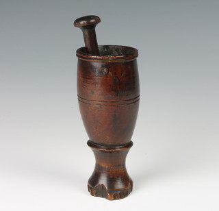 A 17th/18th Century turned wooden mortar with an associated pestle 14cm h x 6cm diam. 