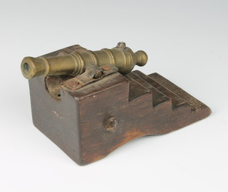 An 18th/19th Century bronze model cannon 10cm, raised on a stepped wooden trunnion 