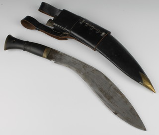 A Kukri with 29cm blade stamped 69 with horn grip contained in a leather scabbard complete with 2 skinning knives and frog 