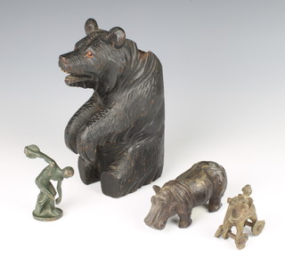 A Swiss carved wooden spill vase in the form of a standing bear 21cm x 8cm x 13cm, an Indian bronze figure of an elephant with rider 7cm x 5cm x 3cm, a bronze figure of a discus thrower 9cm x 1cm x 1cm and a metal figure of a hippopotamus 6cm x 10cm x 4cm   