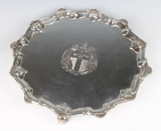 A George III silver salver with shell and scroll rim, raised on scroll feet with chased armorial, London 1764, maker Elizabeth Cooke, 1004 grams, 34 cm  