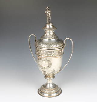 An Edwardian repousse silver 2 handled trophy cup and lid surmounted by a fisherman, the body with floral, grapes and acanthus decoration with presentation inscription, Chester 1906, 1363 grams, 47cm 