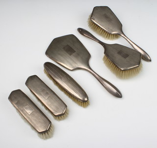 A silver 5 piece dressing table set comprising hand mirror, 2 hair brushes, 2 clothes brushes, Birmingham 1932/1933, a do. clothes brush 