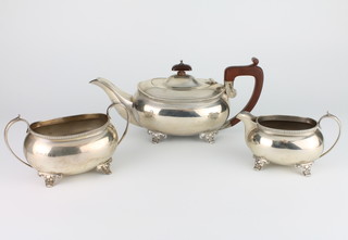 A 3 piece silver tea set of rounded rectangular form with fruitwood handles on scroll feet Birmingham 1931, gross weight 960 grams