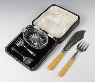 A cased cut glass butter dish with implements and a pair of plated fish servers 