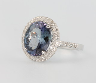 A 14ct white gold oval tanzanite and diamond ring, the centre stone approx. 3.15ct surrounded by brilliant cut diamonds approx. 0.21ct size M 1/2