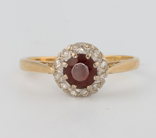 An 18ct yellow gold ruby and diamond cluster ring size N 