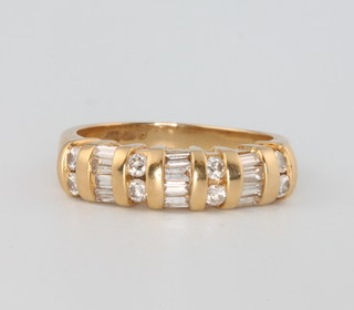 An 18ct yellow gold brilliant and tapered baguette cut diamond ring, comprising 8 brilliant cut diamonds and 12 tapered baguettes, size L 1/2