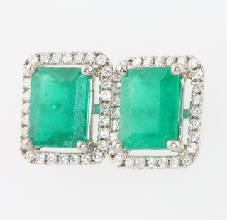 A pair of 18ct white gold emerald and diamond cluster earrings, the emeralds approx. 4.81ct the diamonds approx. 0.6ct 