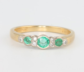 An 18ct yellow gold emerald and diamond ring size M 1/2