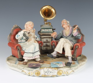 A Capodimonte group of an elderly couple listening to a gramophone, indistinctly signed, 30cm 