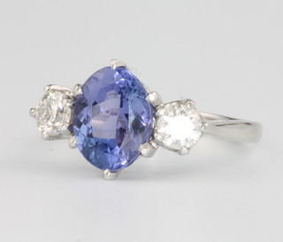 A platinum oval tanzanite and diamond ring, the centre stone approx. 2.8ct flanked by 2 brilliant cut diamonds approx. 0.65ct size O 