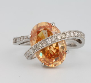 An 18ct white gold oval orange cubic zirconia ring set with brilliant cut diamonds approx. 0.4ct, size O 1/2