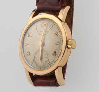 A lady's 18ct yellow gold Longines wristwatch with seconds at 6 o'clock in a 24mm case on a leather strap  