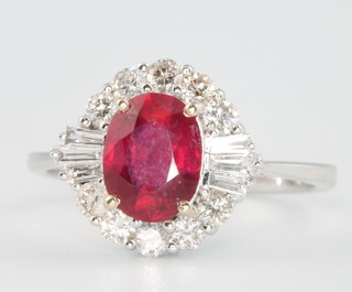 An 18ct white gold oval ruby and diamond cluster ring, the centre stone approx 1.8ct (treated) surrounded by baguette and brilliant cut diamonds approx. 0.58ct, size N 1/2
