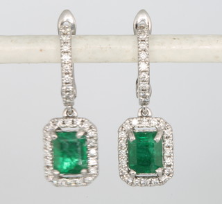 A pair of 18ct white gold rectangular cut emerald and diamond drop earrings, emeralds approx 0.99ct surrounded by brilliant cut diamonds approx 0.28ct 