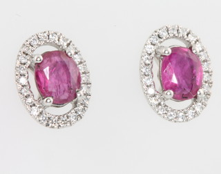 A pair of 18ct white gold oval ruby and diamond ear studs, the rubies approx. 0.95ct surrounded by brilliant cut diamonds approx. 0.16ct 