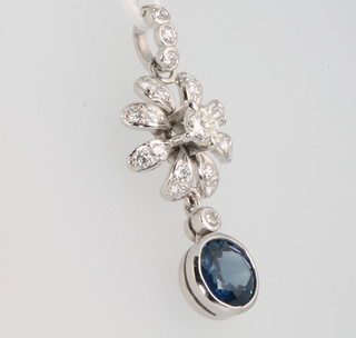 A white gold diamond and sapphire pendant with diamond set loop, diamond set flower head and circular cut sapphire 37mm 