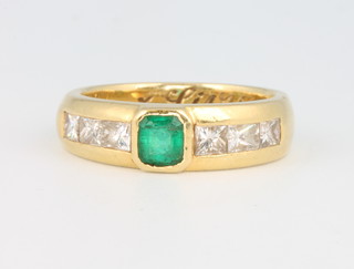 An 18ct yellow gold emerald and diamond ring set with a rectangular cut emerald, flanked by 3 princess cut diamonds, size L 