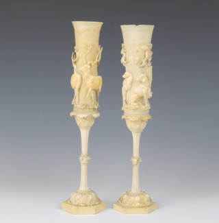 A pair of 19th Century German carved ivory vases with hexagonal bases the stems having hounds heads, the tapered tops with deer, hounds and trees 24.5cm 