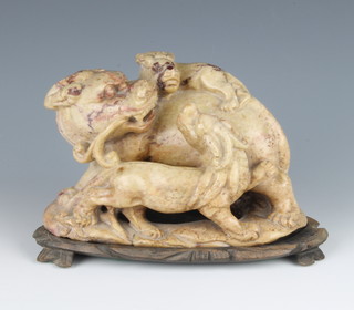 A 19th Century Chinese carved soapstone figure group of a shi shi and cubs in the round 16cm on a hardwood stand
