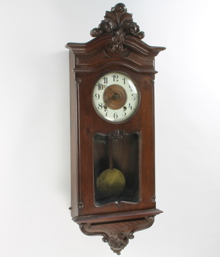 A Continental 8 day striking wall clock with 19cm dial with Roman numerals contained in a carved walnut case 