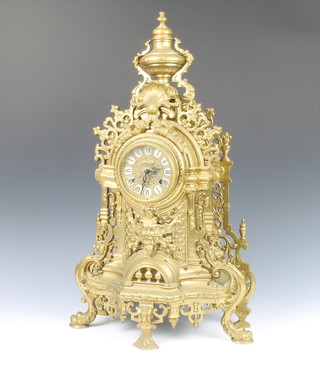 An Italian 8 day striking mantel clock contained in an ornate pierced gilt metal case surmounted by a lidded urn, striking on 2 bells