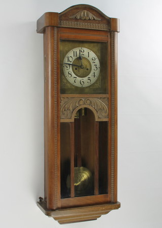 An Art Nouveau French 8 day striking "regulator" wall clock with engraved brass 24cm dial, silvered chapter ring and Roman numerals, contained in a carved walnut case  