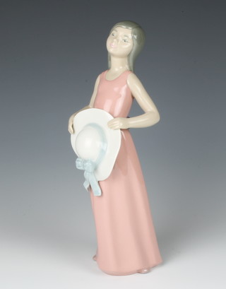 A Lladro figure of a young lady holding a hat 25cm 