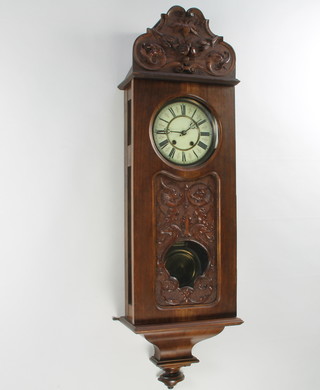 A 19th Century Continental 8 day striking "regulator" with 17.5cm enamelled dial and Roman numerals, with a grid iron pendulum, contained in a carved walnut case 