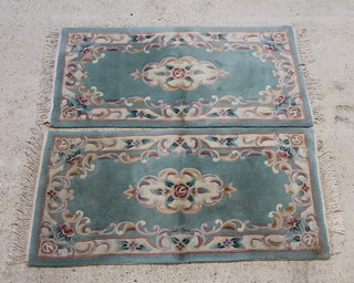 A pair of green ground and floral patterned Indian rugs 155cm x 76cm