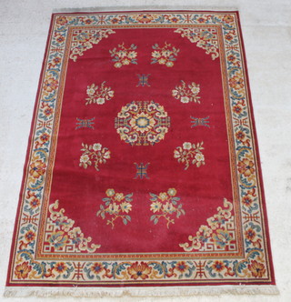 A red ground machine made Persian style carpet with centre medallion and floral borders 280cm x 200cm 