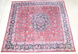 A Persian red and blue ground Mashad carpet with central medallion 335cm x 252cm  