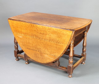 An Edwardian oak oval drop flap gateleg dining table, raised on turned and block supports 73cm h x 121cm w x 60cm when closed x 178cm when open 