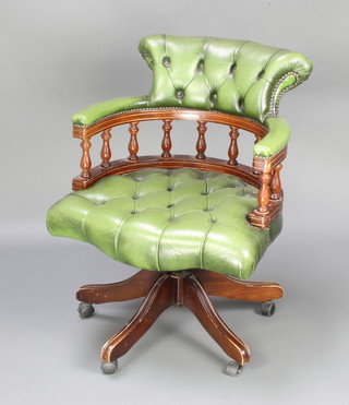 A Victorian style mahogany revolving office chair upholstered in green buttoned leather 