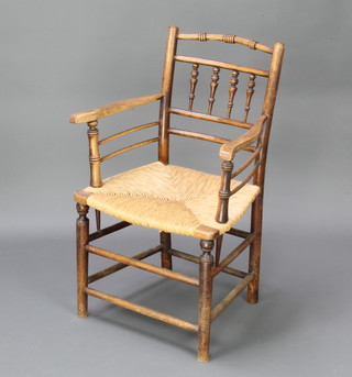 An 18th Century elm bar and spindle back carver chair with woven rush seat and box framed stretcher 