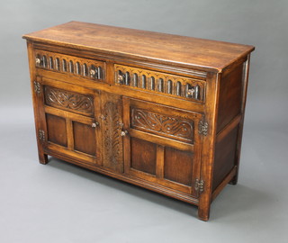 An Ipswich style carved oak dresser fitted 2 long drawers above a double cupboard enclosed by panelled doors with arcaded and carved decoration 86cm h x 125cm w x 47cm d 
