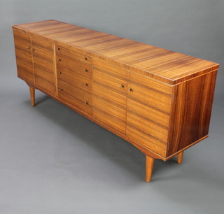 A mid 20th Century AC teak and rosewood finished sideboard fitted 4 long drawers flanked by cupboards enclosed by panelled doors raised on tapered supports 83cm h x 199cm w, the interior labelled AC handcrafted furniture 
