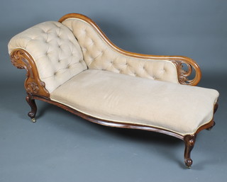 A Victorian carved and pierced mahogany show frame chaise longue upholstered in cream buttoned material and raised on cabriole supports 86cm h x 163cm w x 65cm d 