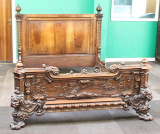An impressive Victorian carved Continental walnut bed frame, the headboard with with turned finials and carved decoration to the side, the rails with egg carving and the footboard heavily carved an interior scene with courtiers raised on lion mask hoof supports, 140cm h x 165cm w x 206 l
