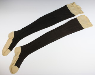 Of Royal Interest, a matched pair of H.M. Queen Victoria's hand stitched black and white silk stockings, the white tops with royal cypher and numbered 4 and 11, circa 1870, 78cm long, 14cm wide 
