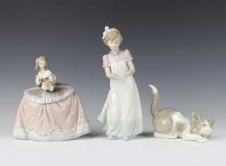 A Lladro figure of a cat crouching 12cm, a do. figure of a girl holding a puppy 15cm another of a girl in a night dress 20cm 