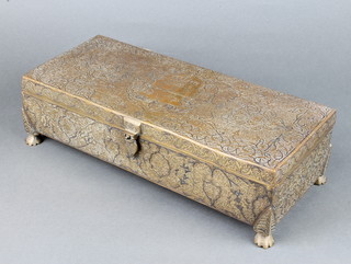 A rectangular Persian/Indian engraved gilt metal casket the lid with armorial decoration raised on paw feet 9cm x 24cm x 15cm 