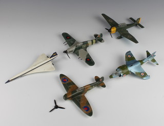 Four Dinky model aircraft - A Junkers JU87B (bomb is missing), a Spitfire Mk2 (propellor f and aerial missing) a Hawker Hurricane Mk2C (propellor damaged and machine gun damaged), a Harrier GR Mk1 together with a Corgi model Concorde (undercarriage missing) 