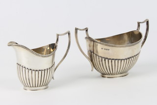 A silver demi-fluted cream jug and sugar bowl Sheffield 1914, maker Thomas Lambourne 296 grams 