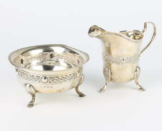 An Irish silver cream jug with Cymric style decoration on pad feet, a do. sugar bowl Dublin 1911, 350 grams