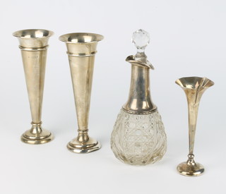 A pair of Edwardian silver tapered spill vases 19cm, London 1907, a small do. and a mounted spirit bottle